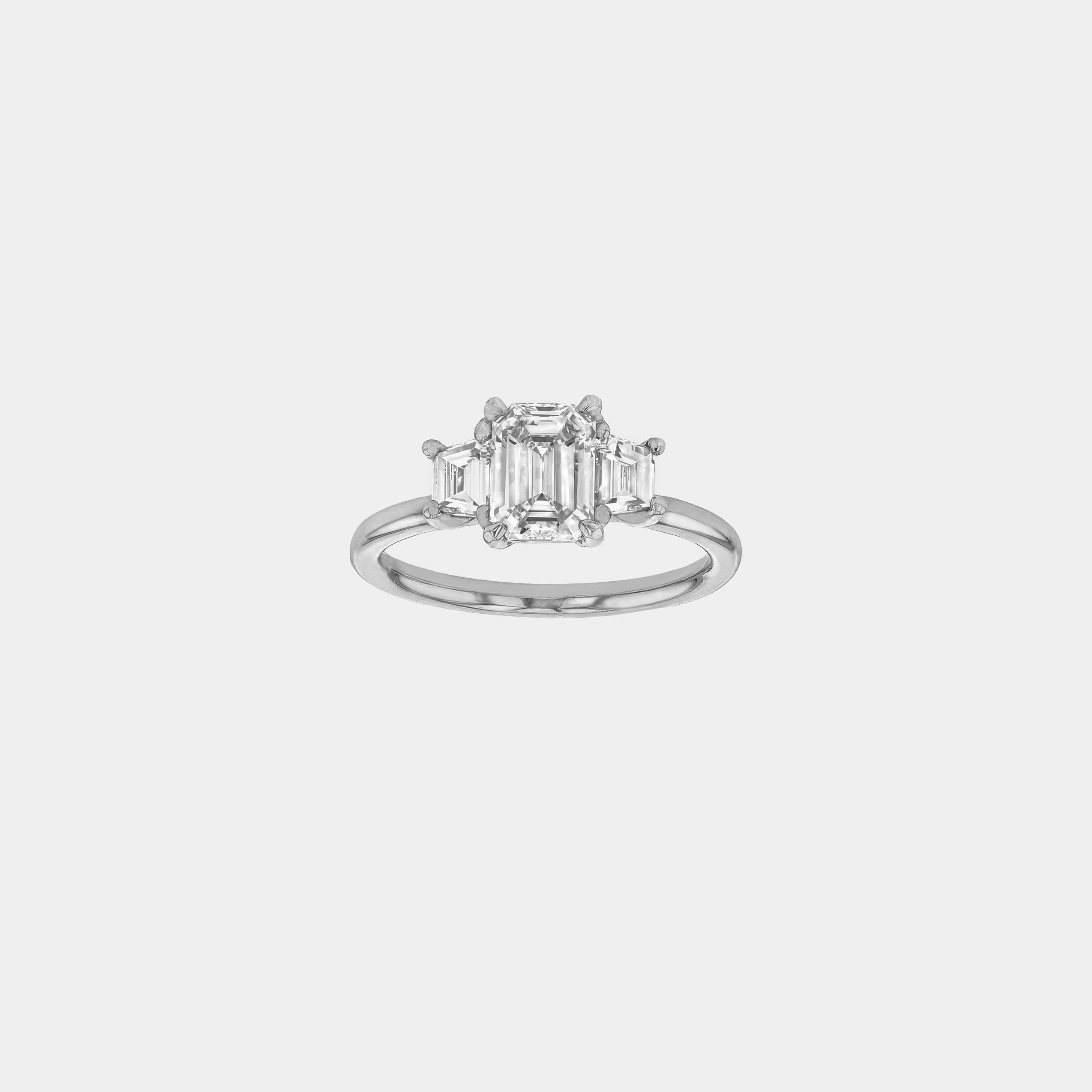 Rings-The Evangeline enhances the intriguing beauty of the emerald-cut diamond with the trapeze cut side stones. The trilogy creates a stunningly geometric shape that is modern and timeless. With the high setting of the stones this engagement ring sits flush with all wedding bands, we recommend pairing with the Bamboo and the Petite Nadia.-ELIISE MAAR JEWELLERY