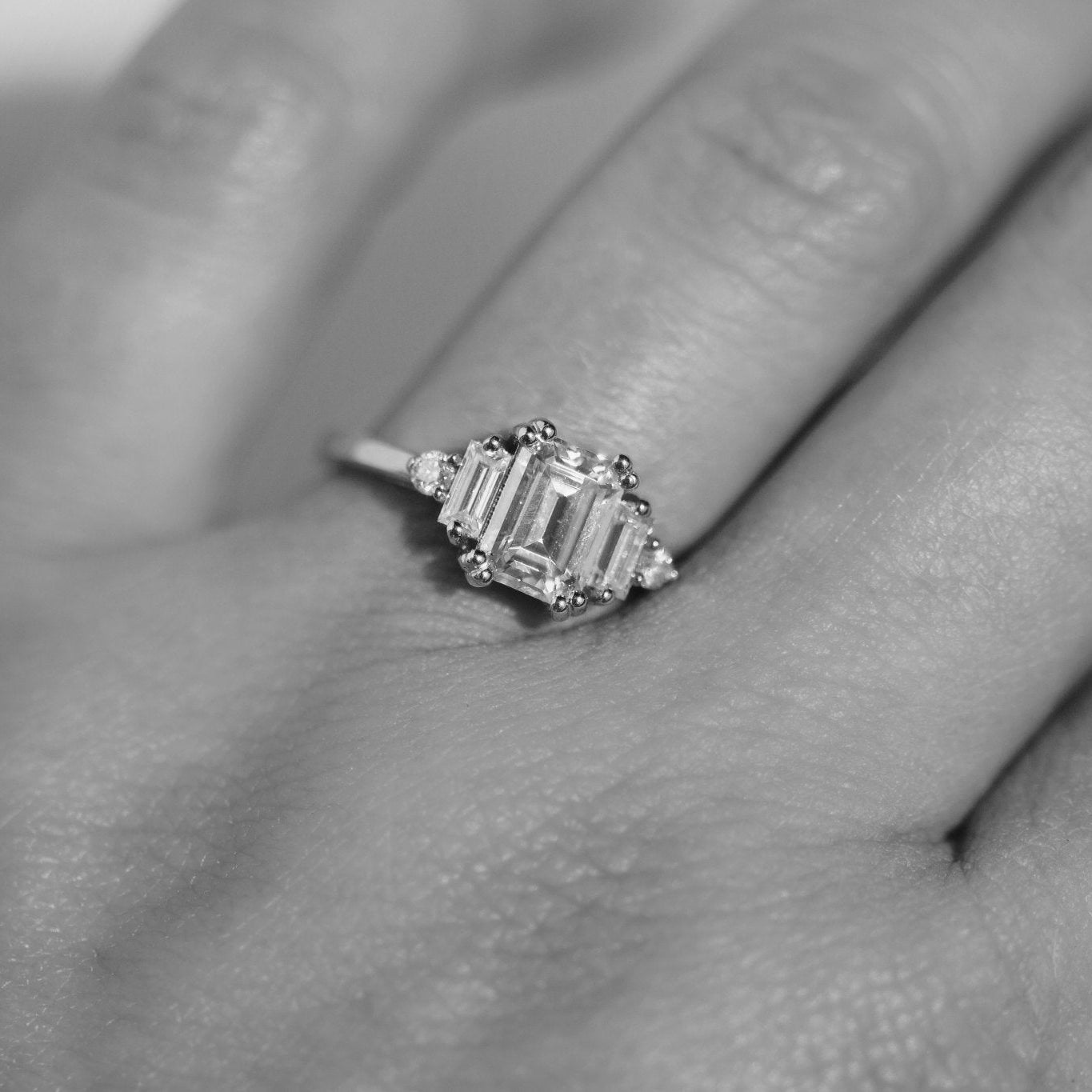 Rings-Product Details - Features an 7 x 5mm emerald cut Supernova Moissanite as the centre stone and baguette and round on the sides- Moissanite is a laboratory created gemstone that is very durable making it suitable for an engagement ring and everyday wear. Moissanite is not a lab grown diamond. The ring will come with a card of authenticity stating that it is featuring a Supernova Moissanite.- The ring is 1.80mm wide and thick-ELIISE MAAR JEWELLERY