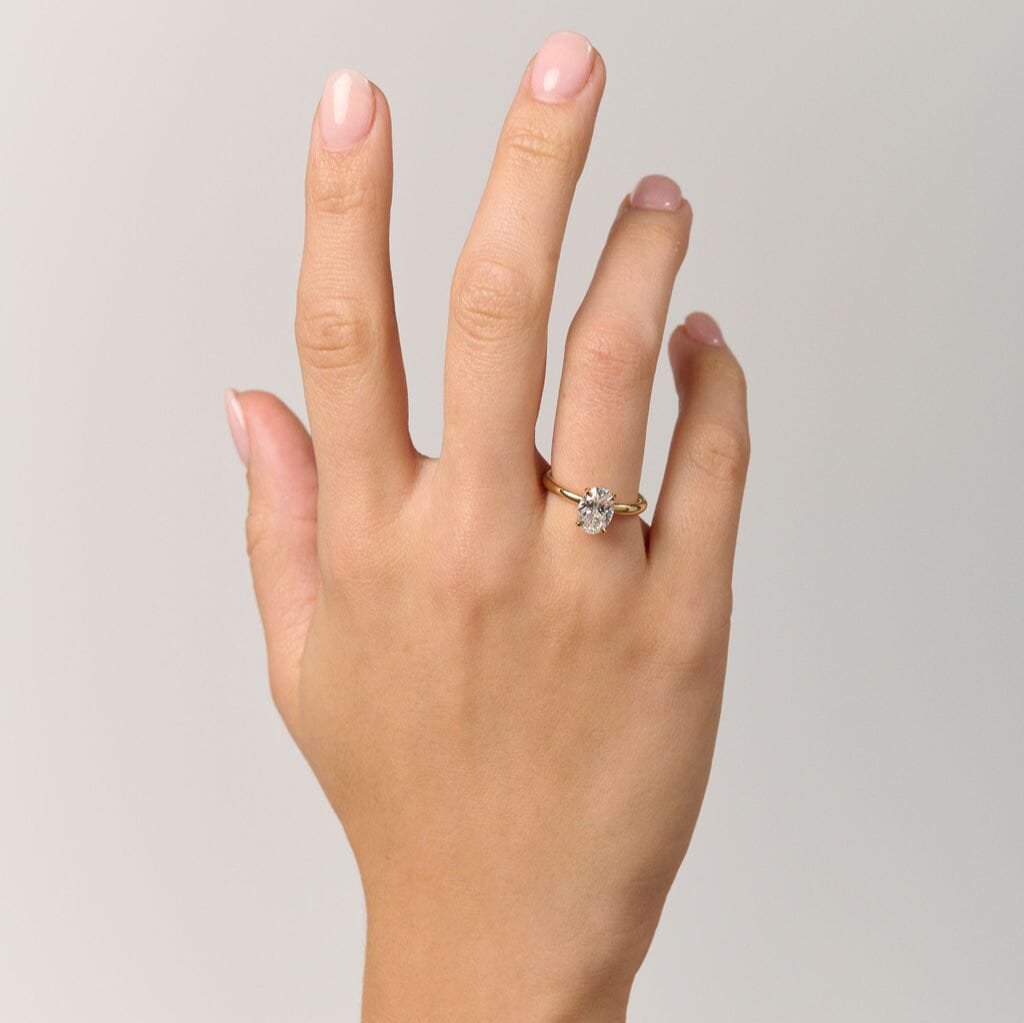 Rings-Drawing inspiration from Grace Kelly, this solitaire ring embodies timeless elegance. Featuring a 4-claw setting and a smoothly rounded band, it offers a subtle frame that highlights the radiant oval diamond at its center. An ideal engagement ring, it complements any wedding band to form a distinctive and personalized set. Shown paired with the 4.0mm Ceremonial Square Band and the Eleanor Luxe Diamond Band.-ELIISE MAAR JEWELLERY