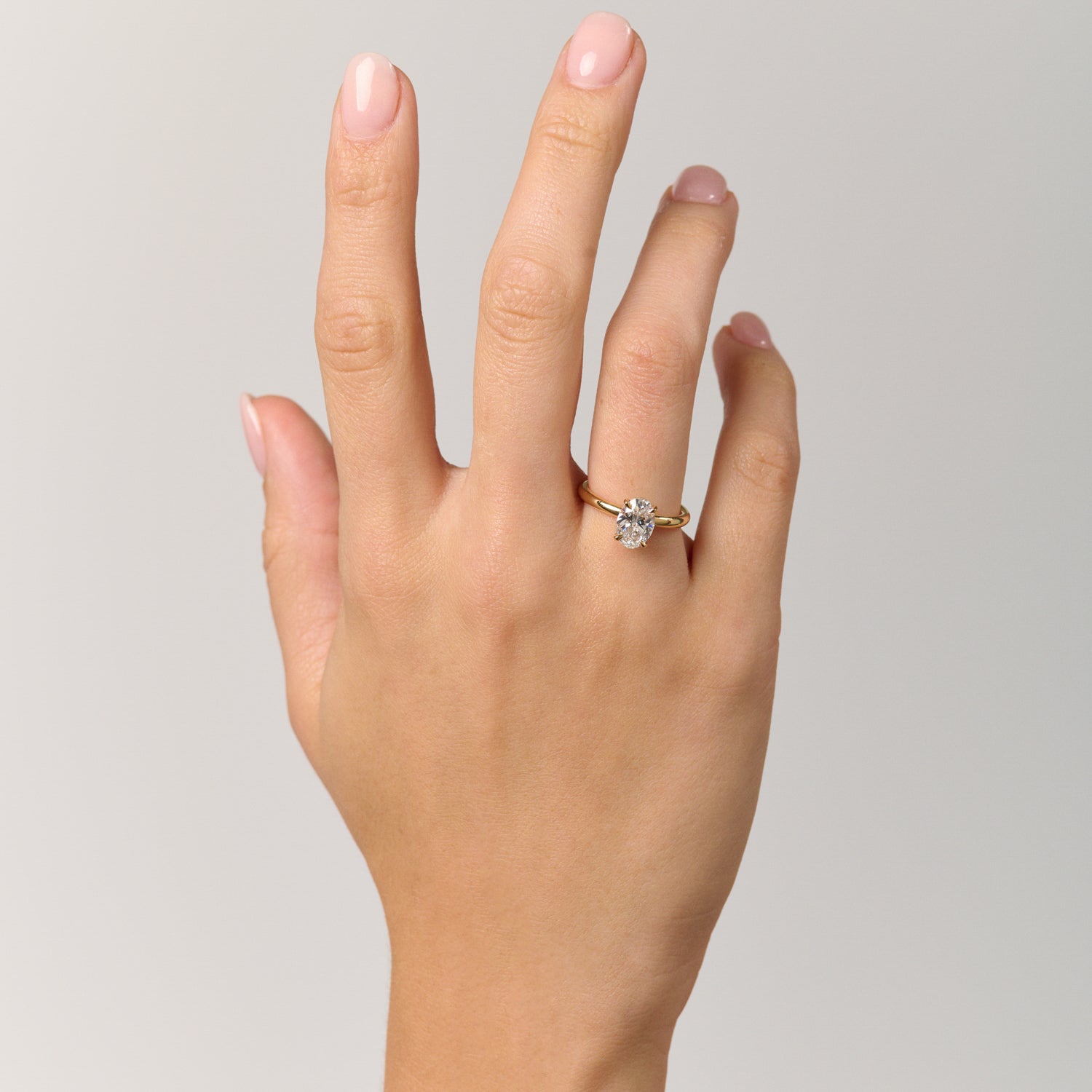 Rings-Drawing inspiration from Grace Kelly, this solitaire ring embodies timeless elegance. Featuring a 4-claw setting and a smoothly rounded band, it offers a subtle frame that highlights the radiant oval diamond at its center. An ideal engagement ring, it complements any wedding band to form a distinctive and personalized set. Shown paired with the 4.0mm Ceremonial Square Band and the Eleanor Luxe Diamond Band.-ELIISE MAAR JEWELLERY