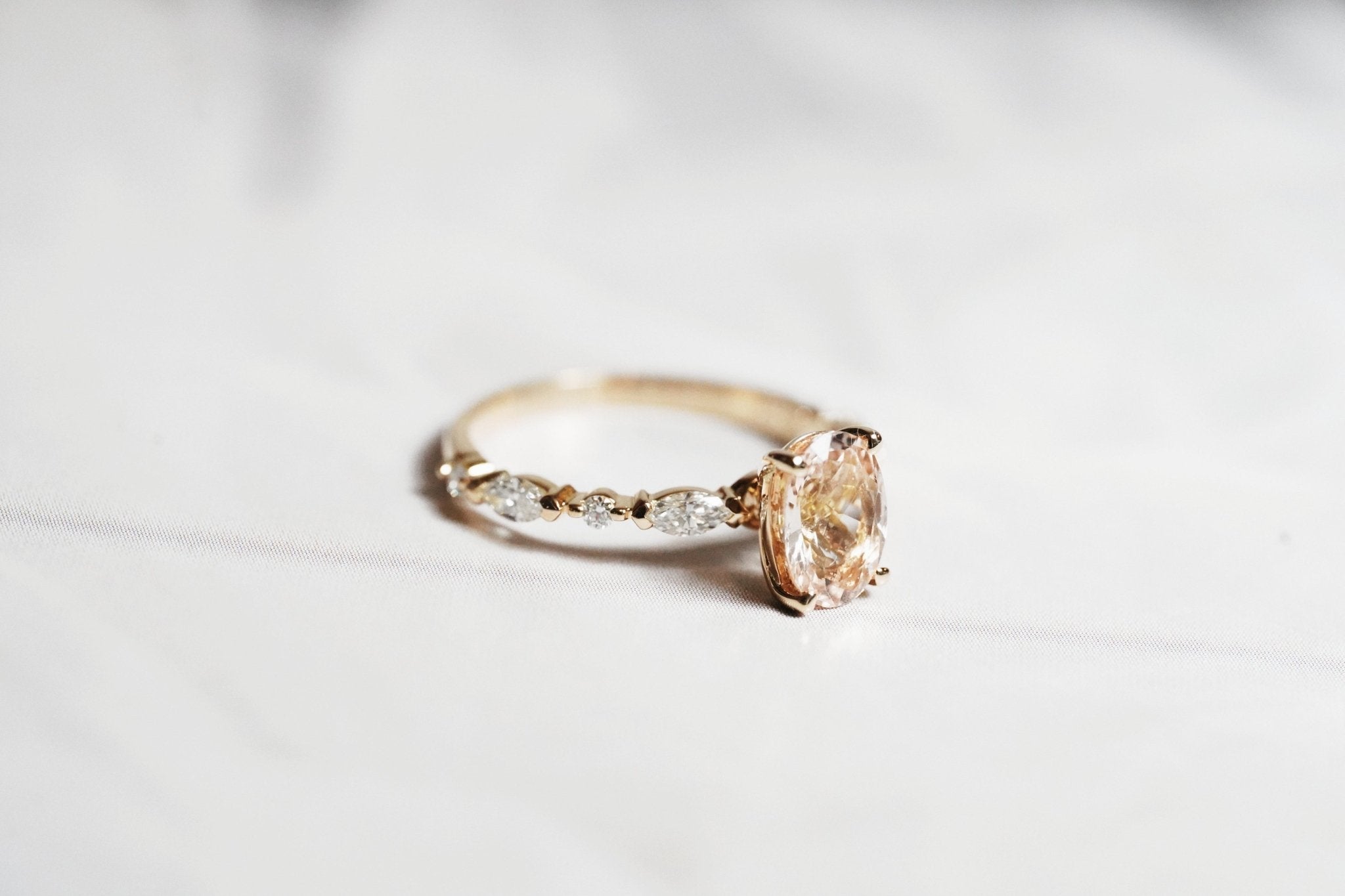 Rings-One of our most beloved designs. The Kelly features a stunning centre morganite surrounded by a band holding marquise and round-cut diamonds. This ring is a stunning reflection of love with its intricate design and endless sparkle. We recommend pairing the Kelly with the Eleni Diamond Band or the Eleanor Diamond Band. Product Details - Featuring a natural 8x6mm peachy-pinky Morganite centre stone- The ring is 2mm thick and 1.80mm wide - The side stones are marquise and round brilliant cut natural diam