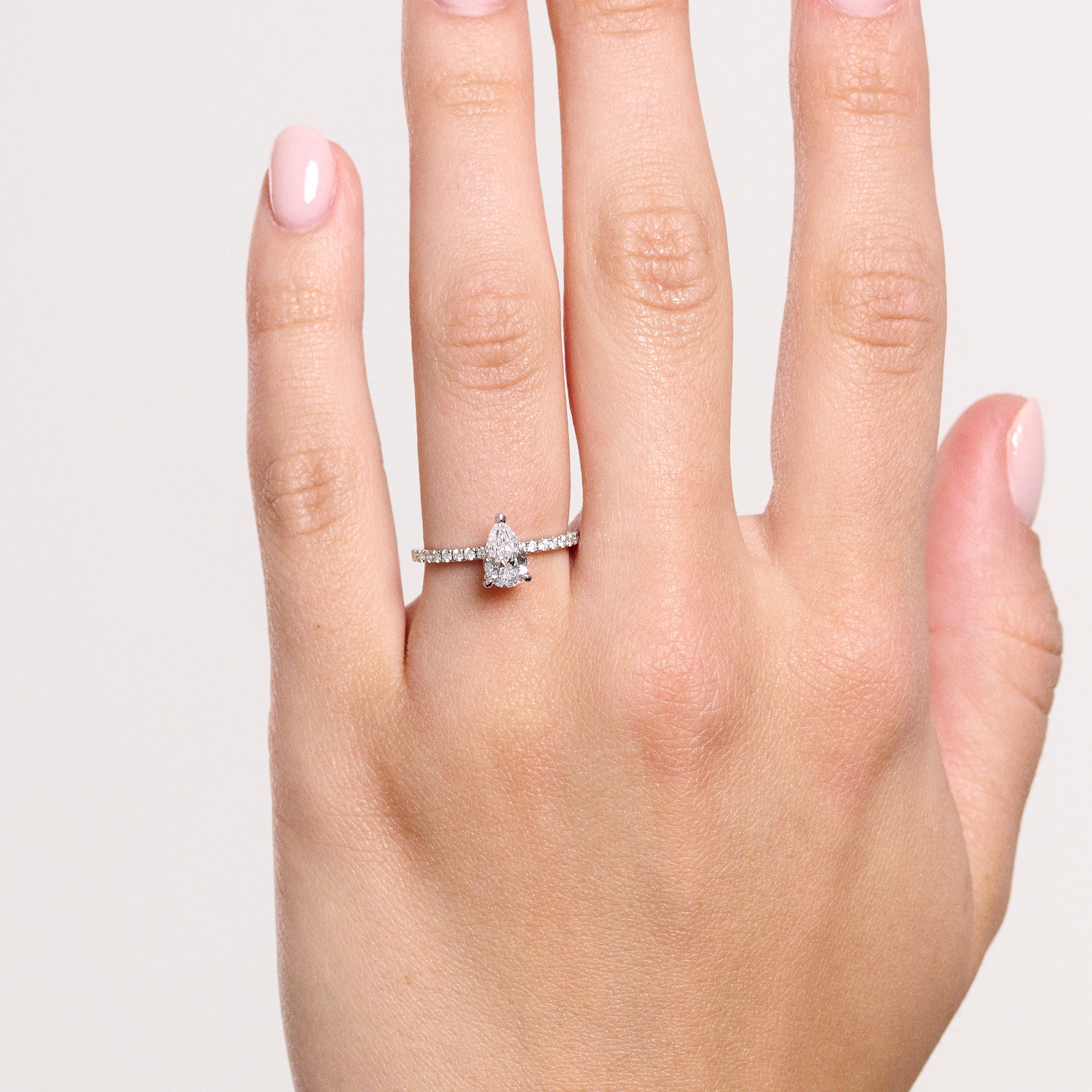 Rings-A elegant engagement ring with a beautiful half eternity pavé diamond band. The striking fire of the side diamonds enhance the brilliance of the oval cut centre diamond. Pair the Lena with with Fine Lavish diamond band for a matching set. Available with an oval or pear shaped diamond.-ELIISE MAAR JEWELLERY