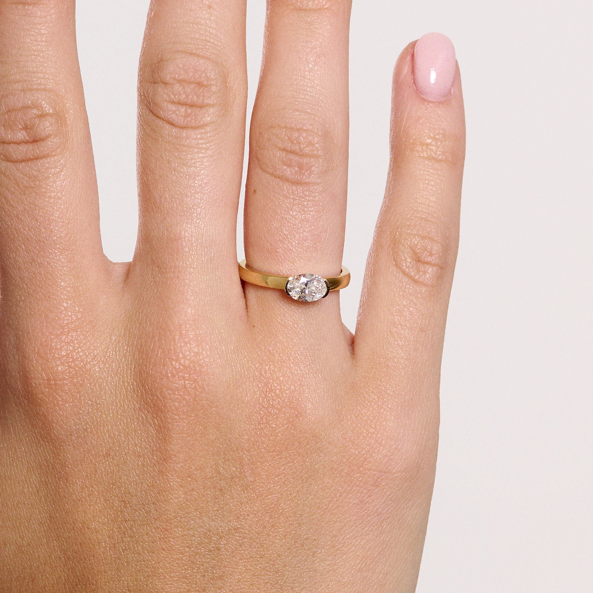 Rings-A contemporary take on the classic solitaire, the Margot is designed for the modern wearer. With an east-west set oval cut center diamond on a thick band, this ring is bold and sleek. See the Margot paired with the Josephine Luxe Diamond Band. Available with different size oval diamonds. Product images featuring an option with 1.00ct center diamond and 0.70ct diamond.-ELIISE MAAR JEWELLERY