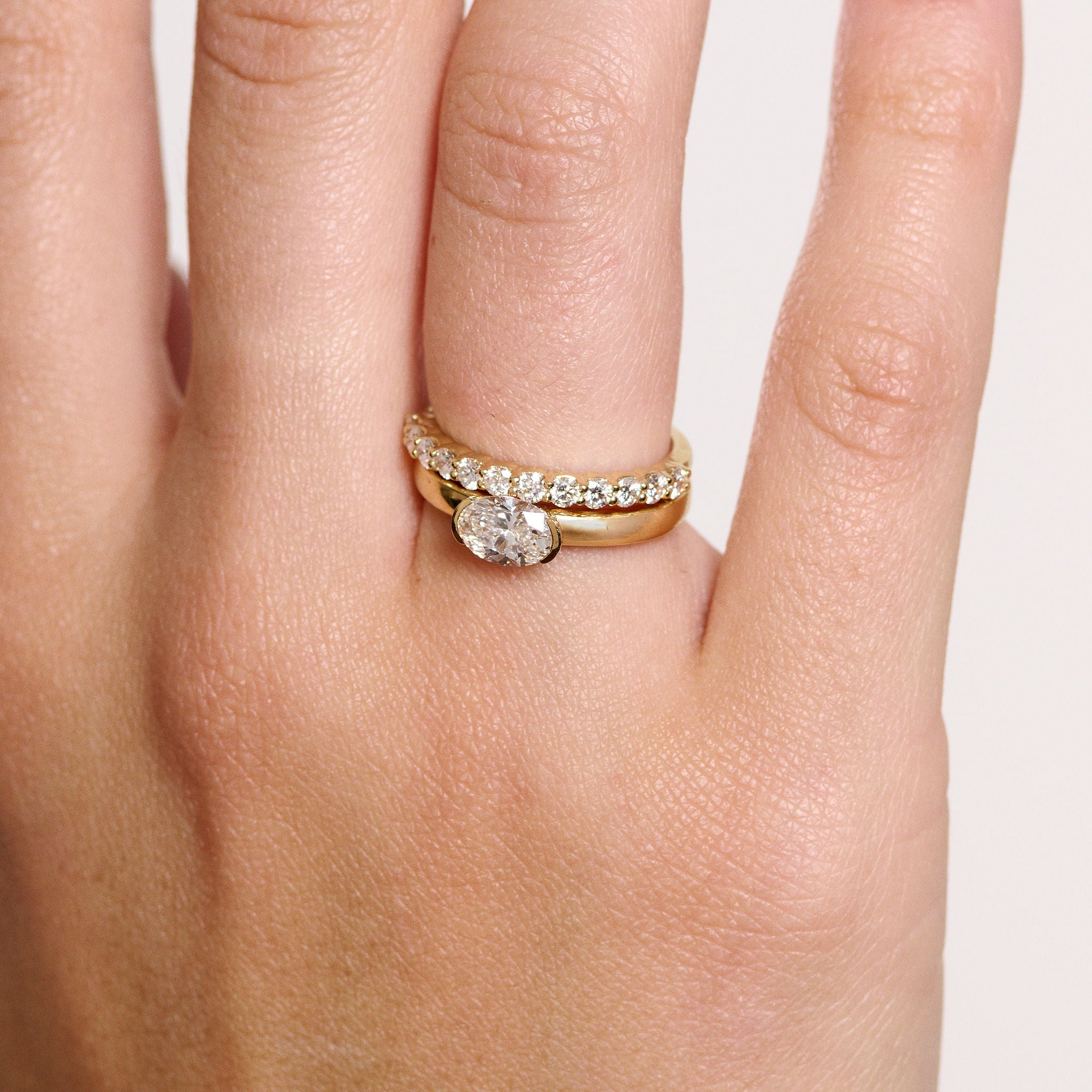 Rings-A contemporary take on the classic solitaire, the Margot is designed for the modern wearer. With an east-west set oval cut center diamond on a thick band, this ring is bold and sleek. See the Margot paired with the Josephine Luxe Diamond Band. Available with different size oval diamonds. Product images featuring an option with 1.00ct center diamond and 0.70ct diamond.-ELIISE MAAR JEWELLERY