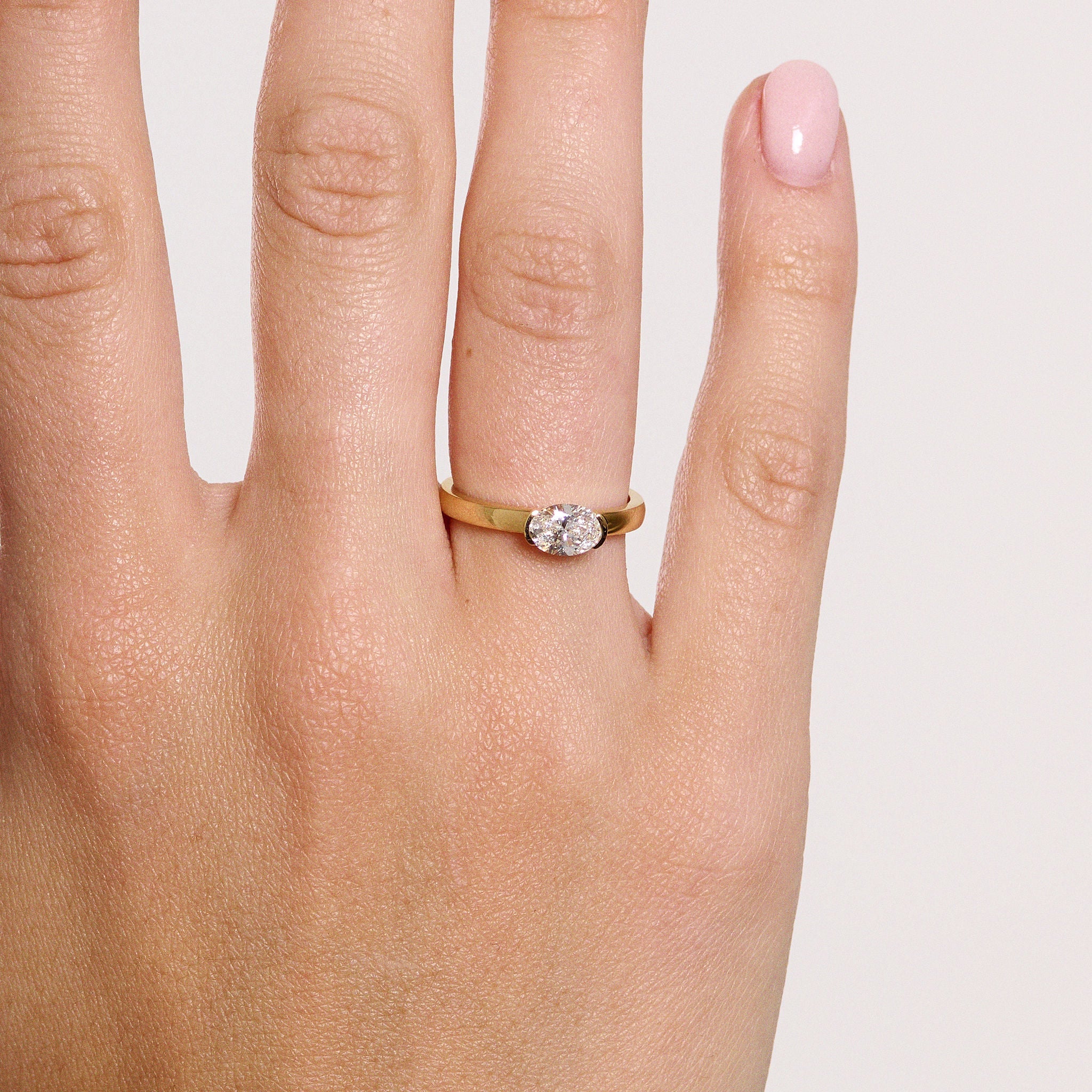 Rings-A contemporary take on the classic solitaire, the Margot is designed for the modern wearer. With an east-west set oval cut center diamond on a thick band, this ring is bold and sleek. See the Margot paired with the Josephine Luxe Diamond Band. Available with different size oval diamonds. Product images featuring an option with 1.00ct center diamond and 0.70ct diamond.-ELIISE MAAR JEWELLERY