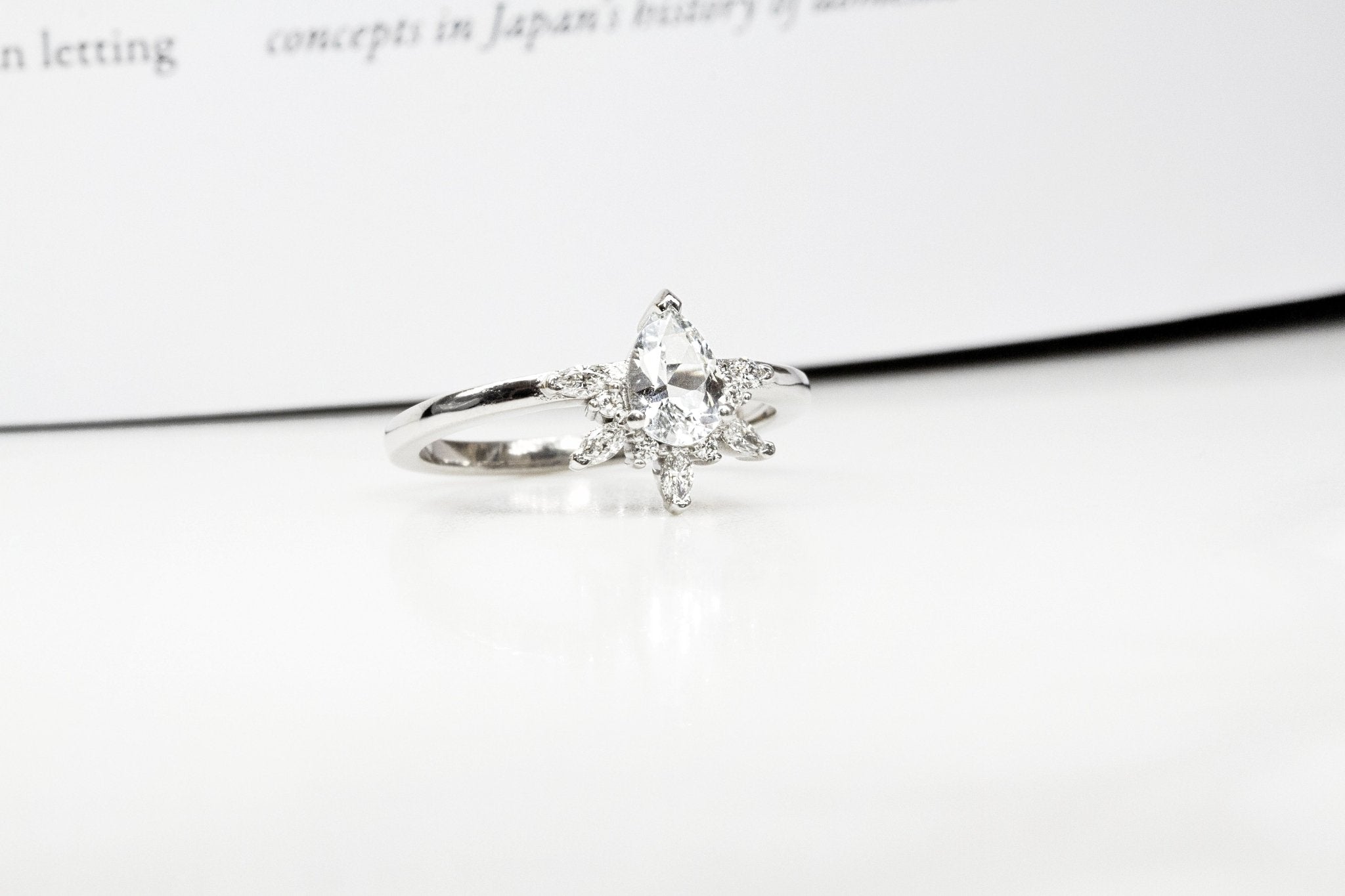 Rings-Feminine, nostalgic nod to the beauty, timelessness and grace of what it means to be woman. Centre stone is a stunning white sapphire completed with a divine diamond halo. Destined to be your forever obsession. Product Details - Features a 0.70ct natural white sapphire- Half halo features marquise and round F/SI1 natural diamonds (approximately 0.20ct)- Shop the Natasha Diamond Crown to complete the set- The ring is 1.85mm wide and 1.6mm thick-ELIISE MAAR JEWELLERY