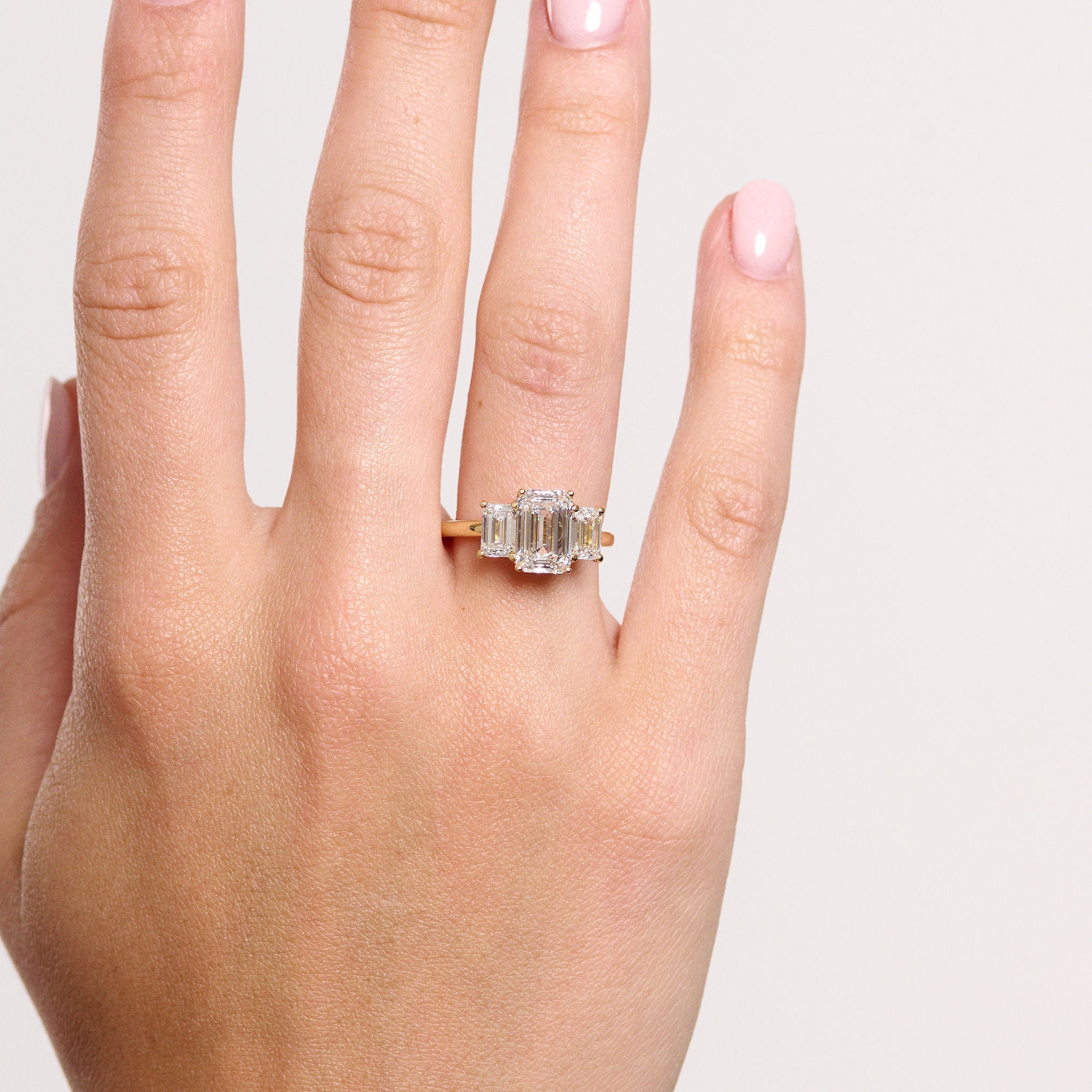 Rings-A stunning trilogy ring featuring three emerald-cut diamonds. Ethereal and breathtaking, this ring is a true testament to the beauty of the emerald-cut diamond. The step cut inside the emerald-cut diamond is famous for its large windows and flashes of bright white light. A ring where the quality and beauty of the diamonds cannot be ignored.-ELIISE MAAR JEWELLERY