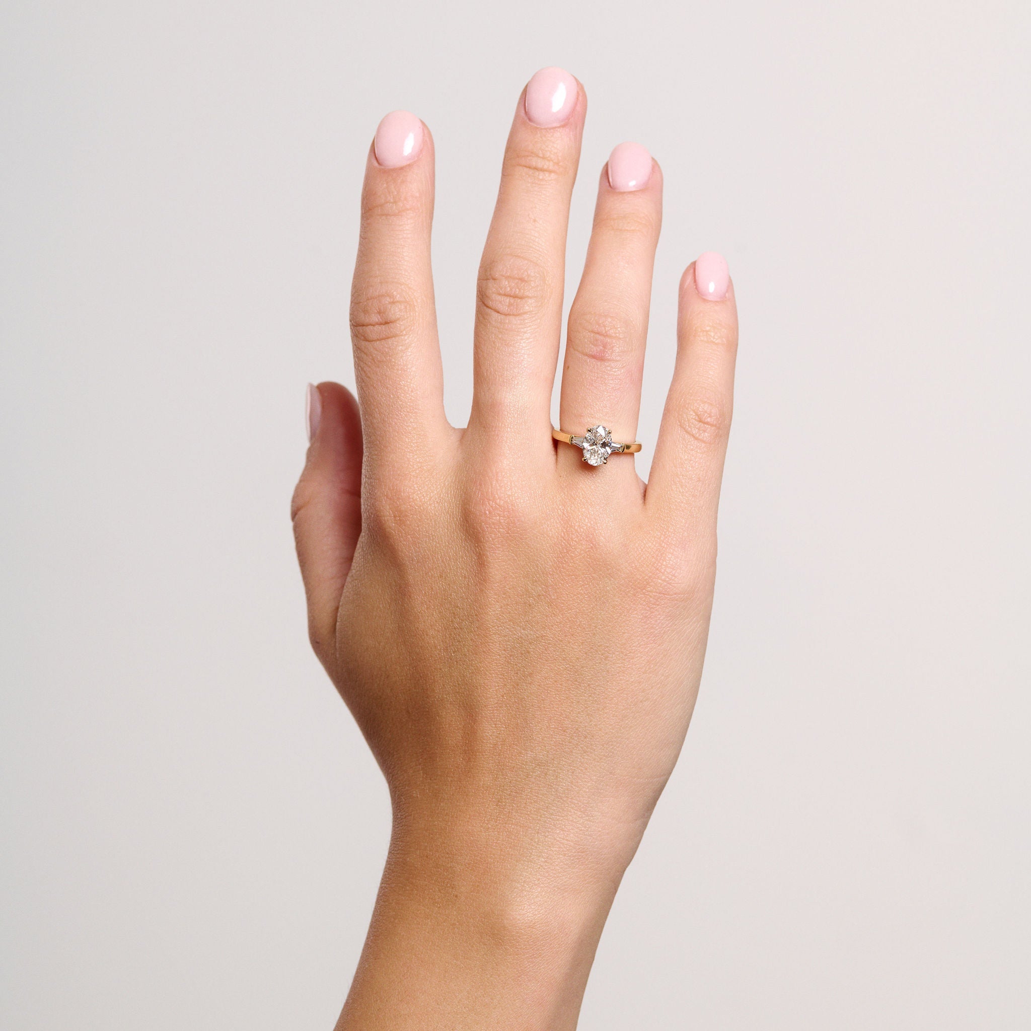 Rings-The Willow is a captivating engagement ring. The side tapered baguette cut stones create a beautiful crescendo to the centre oval cut diamond. The thicker band creates a ring that is structured and impactful. Shown paired with the Petite Nadia.-ELIISE MAAR JEWELLERY