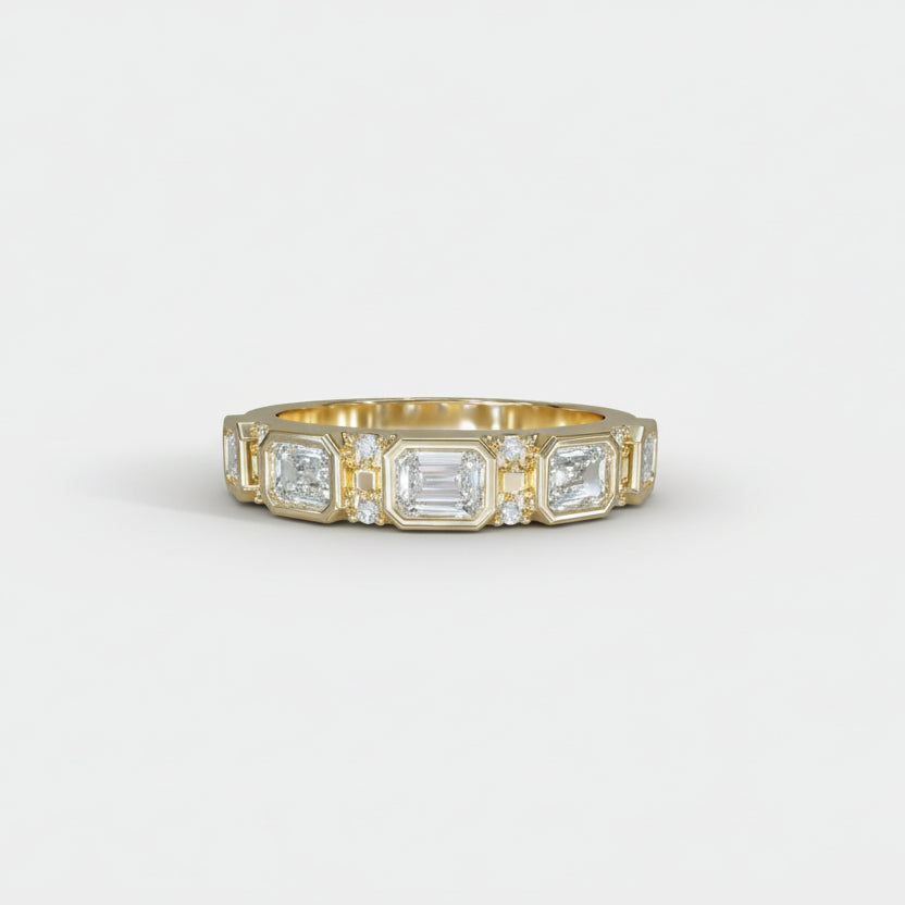 Gold ring with emerald-cut diamonds on a light gray background