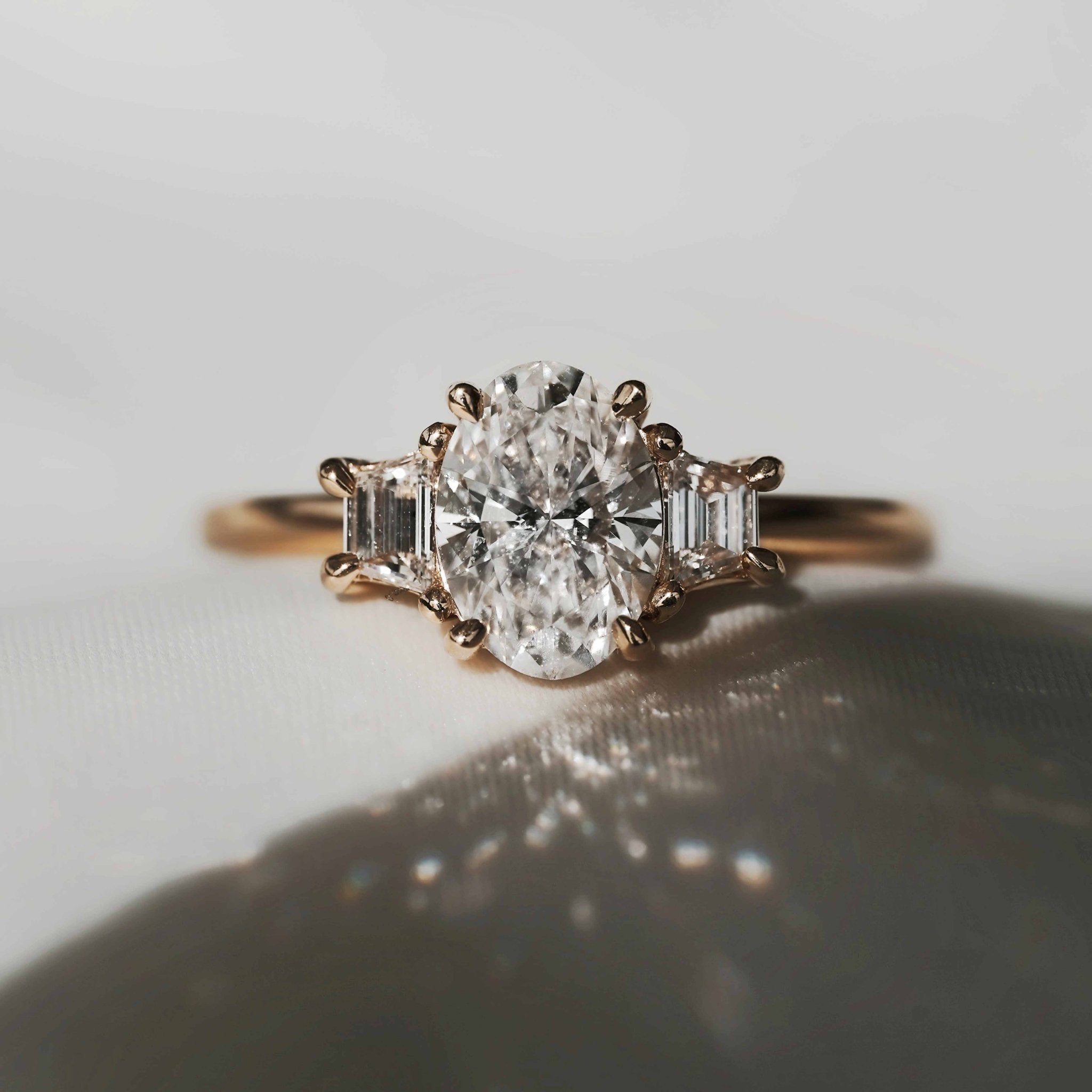 Rings-The Aria is a modern ring with an antique look. The combination of the oval cut centre diamond with the trapeze-cut side stones creates a trilogy that is elegant and striking. A stunning band that pairs well with all wedding bands, we suggest trying with the Josephine Luxe or the Fine Lavish. VIDEO-ELIISE MAAR JEWELLERY