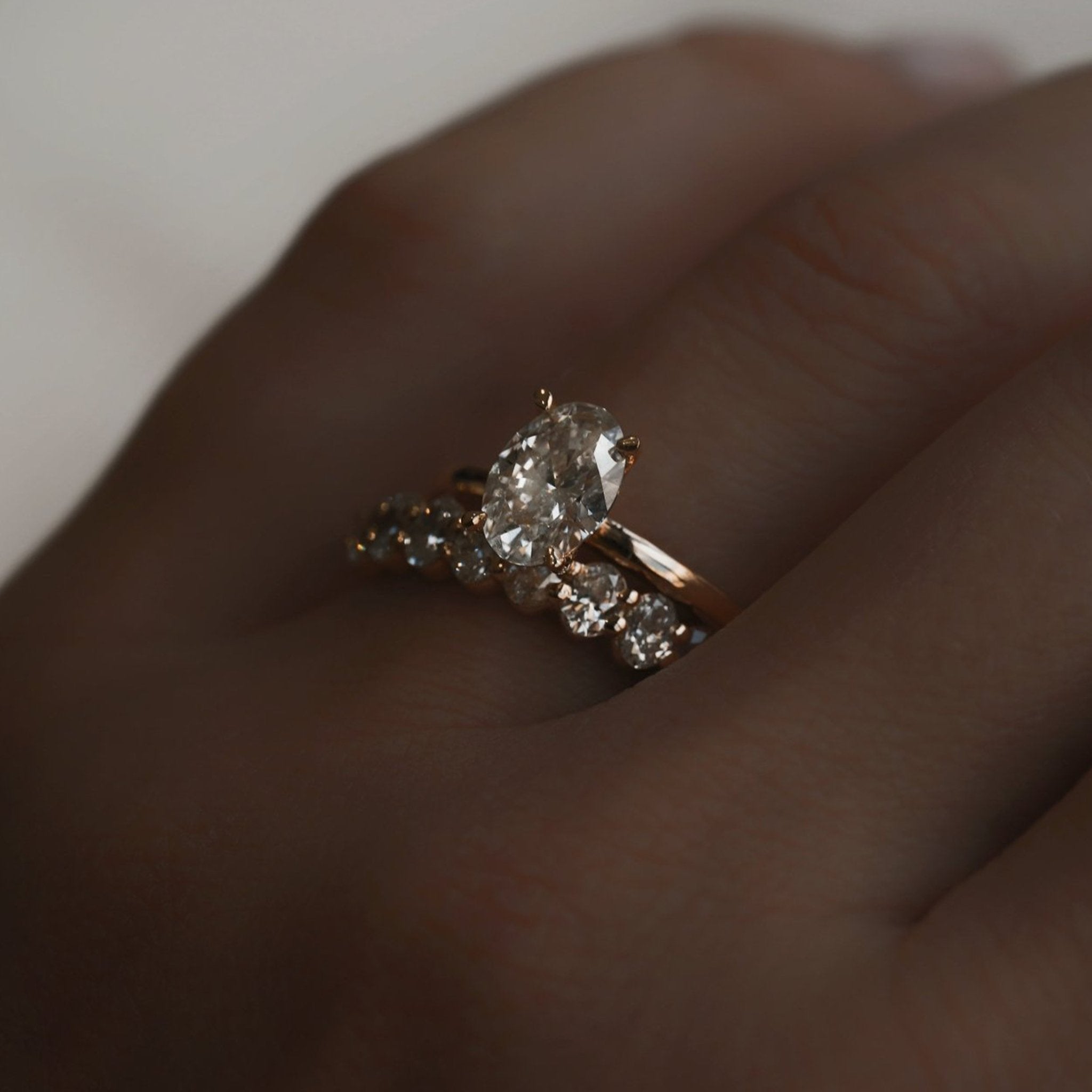 Rings-Drawing inspiration from Grace Kelly, this solitaire ring embodies timeless elegance. Featuring a 4-claw setting and a smoothly rounded band, it offers a subtle frame that highlights the radiant oval diamond at its center. An ideal engagement ring, it complements any wedding band to form a distinctive and personalized set. Shown paired with the 4.0mm Ceremonial Square Band and the Eleanor Luxe Diamond Band.-ELIISE MAAR JEWELLERY