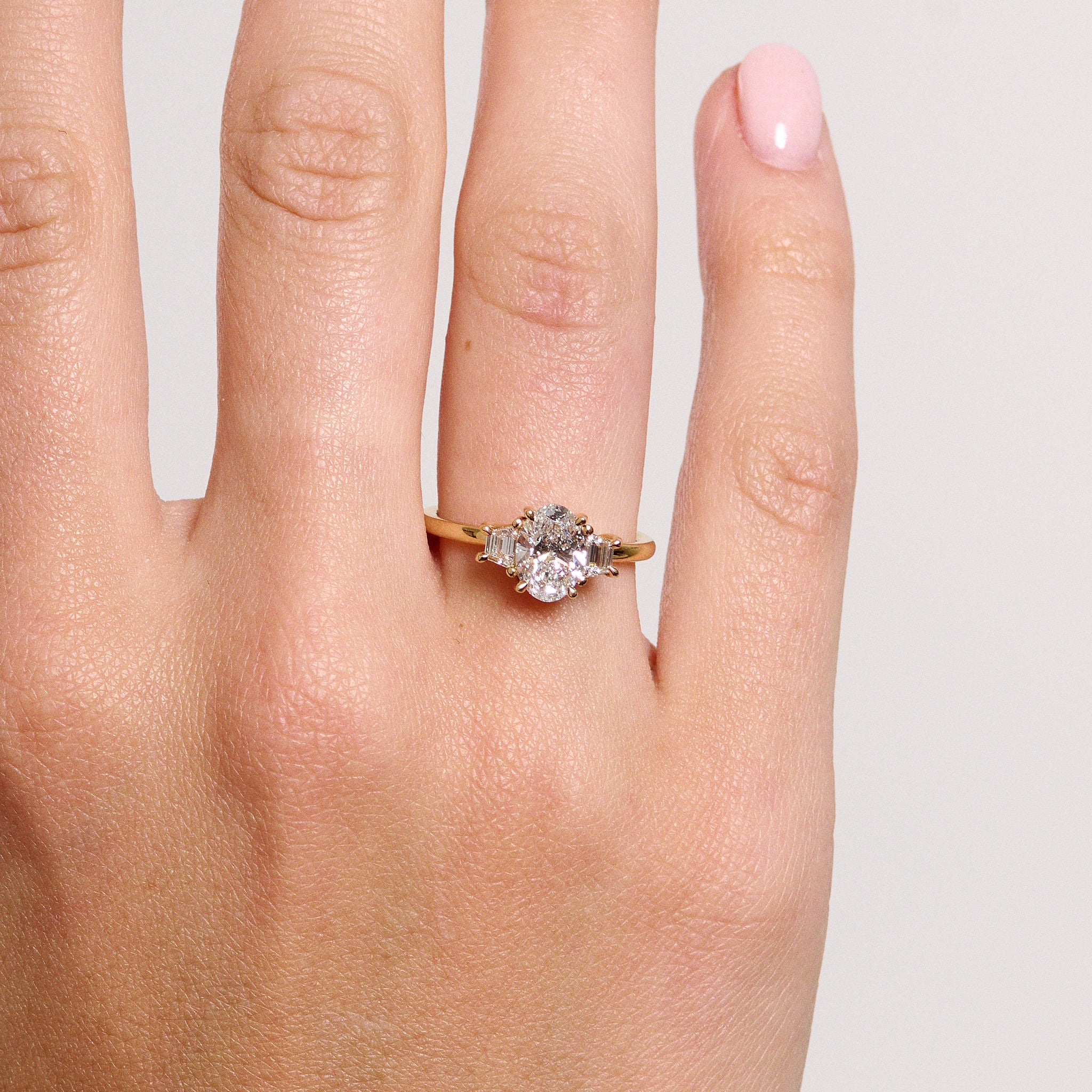 Rings-The Aria is a modern ring with an antique look. The combination of the oval cut centre diamond with the trapeze-cut side stones creates a trilogy that is elegant and striking. A stunning band that pairs well with all wedding bands, we suggest trying with the Josephine Luxe or the Fine Lavish. VIDEO-ELIISE MAAR JEWELLERY