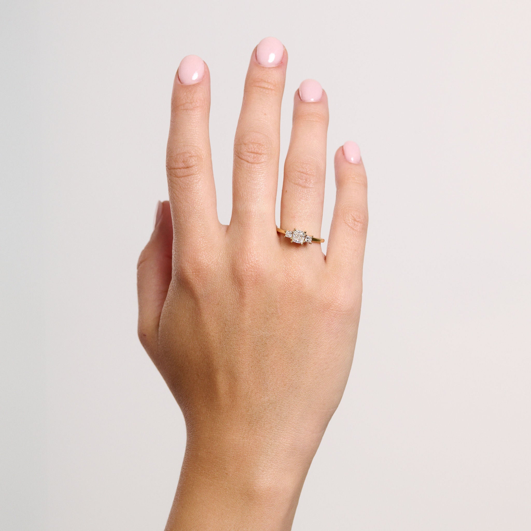 Rings-This elegant trilogy features a cushion cut centre diamond with a brilliant princess cut 0.30ct diamond on either side. VIDEO-ELIISE MAAR JEWELLERY