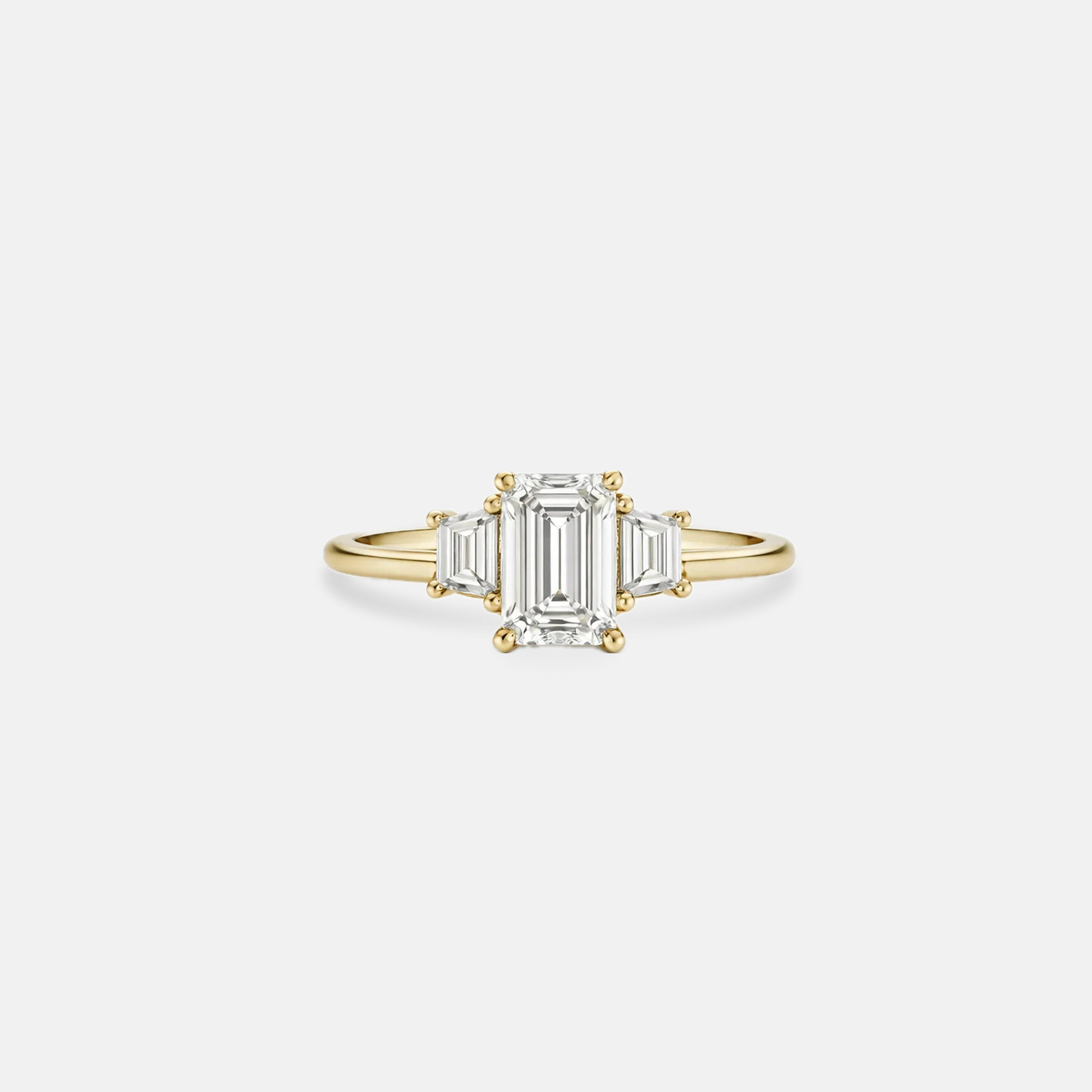 Rings-The Evangeline enhances the intriguing beauty of the emerald-cut diamond with the trapeze cut side stones. The trilogy creates a stunningly geometric shape that is modern and timeless. With the high setting of the stones this engagement ring sits flush with all wedding bands, we recommend pairing with the Bamboo and the Petite Nadia.-ELIISE MAAR JEWELLERY