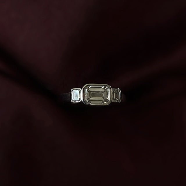 Rings-In the realm of timeless romance, the HERR Diamond Trilogy Ring stands as a beacon of enduring love and shared destiny. Featuring an east-west emerald-cut centre stone, flanked by two complementary emerald-cut diamonds. Cradled in a bezel setting that accentuates their brilliance, the trilogy symbolizes the cherished past, vibrant present, and boundless future of a couple's journey together. As part of the esteemed Le Courage collection, the HERR Diamond Trilogy Ring celebrates the courage inherent in