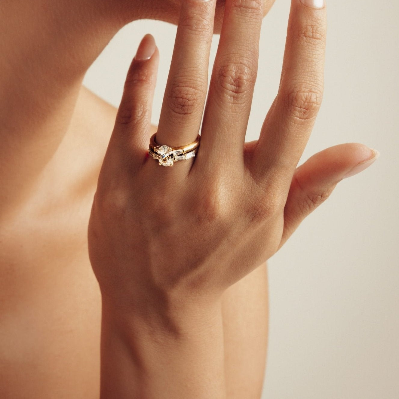 Rings-The Willow is a captivating engagement ring. The side tapered baguette cut stones create a beautiful crescendo to the centre oval cut diamond. The thicker band creates a ring that is structured and impactful. Shown paired with the Petite Nadia.-ELIISE MAAR JEWELLERY