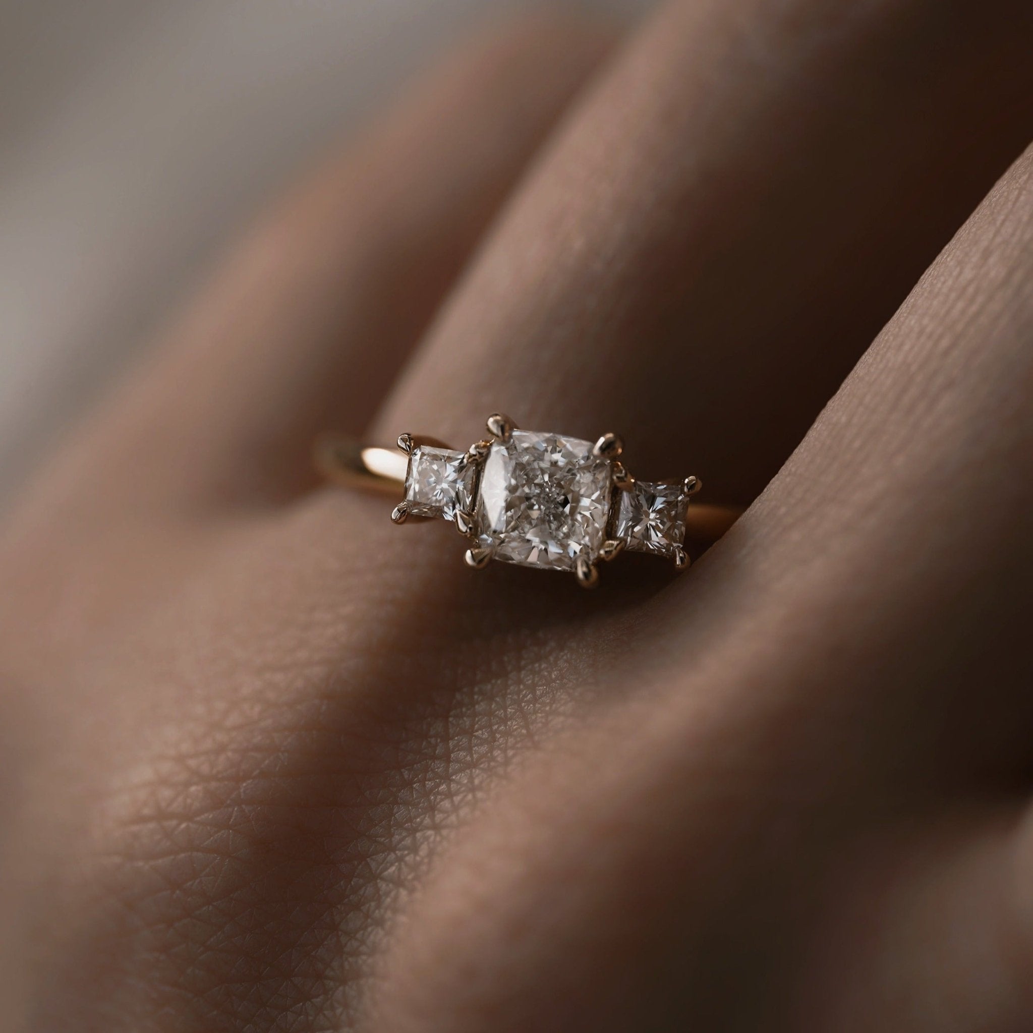 Rings-This elegant trilogy features a cushion cut centre diamond with a brilliant princess cut 0.30ct diamond on either side. VIDEO-ELIISE MAAR JEWELLERY