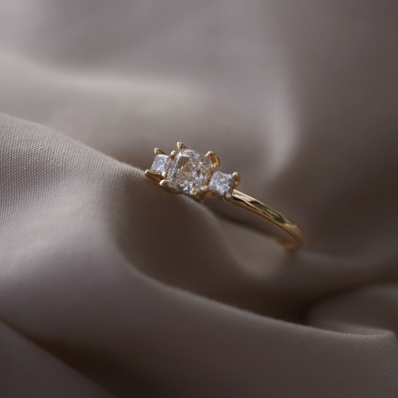 Rings-This elegant trilogy features a cushion cut centre diamond with a brilliant princess cut 0.30ct diamond on either side. VIDEO-ELIISE MAAR JEWELLERY
