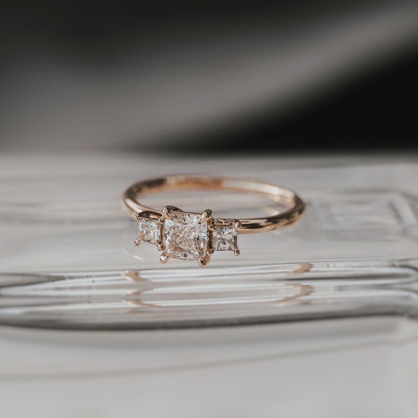 Rings-This elegant trilogy features a cushion cut centre diamond with a brilliant princess cut 0.30ct diamond on either side. VIDEO-ELIISE MAAR JEWELLERY