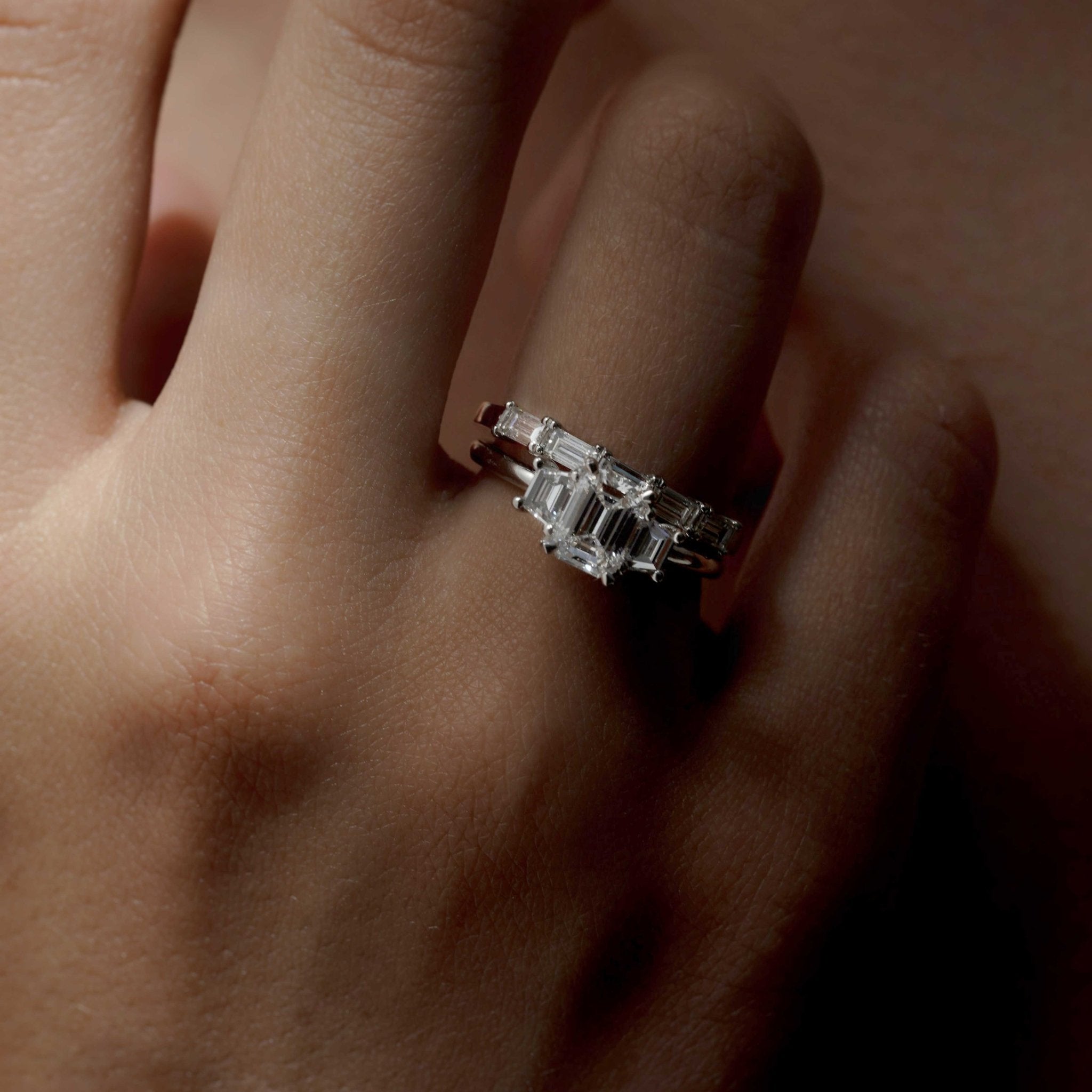 Rings-The Evangeline enhances the intriguing beauty of the emerald-cut diamond with the trapeze cut side stones. The trilogy creates a stunningly geometric shape that is modern and timeless. With the high setting of the stones this engagement ring sits flush with all wedding bands, we recommend pairing with the Bamboo and the Petite Nadia.-ELIISE MAAR JEWELLERY