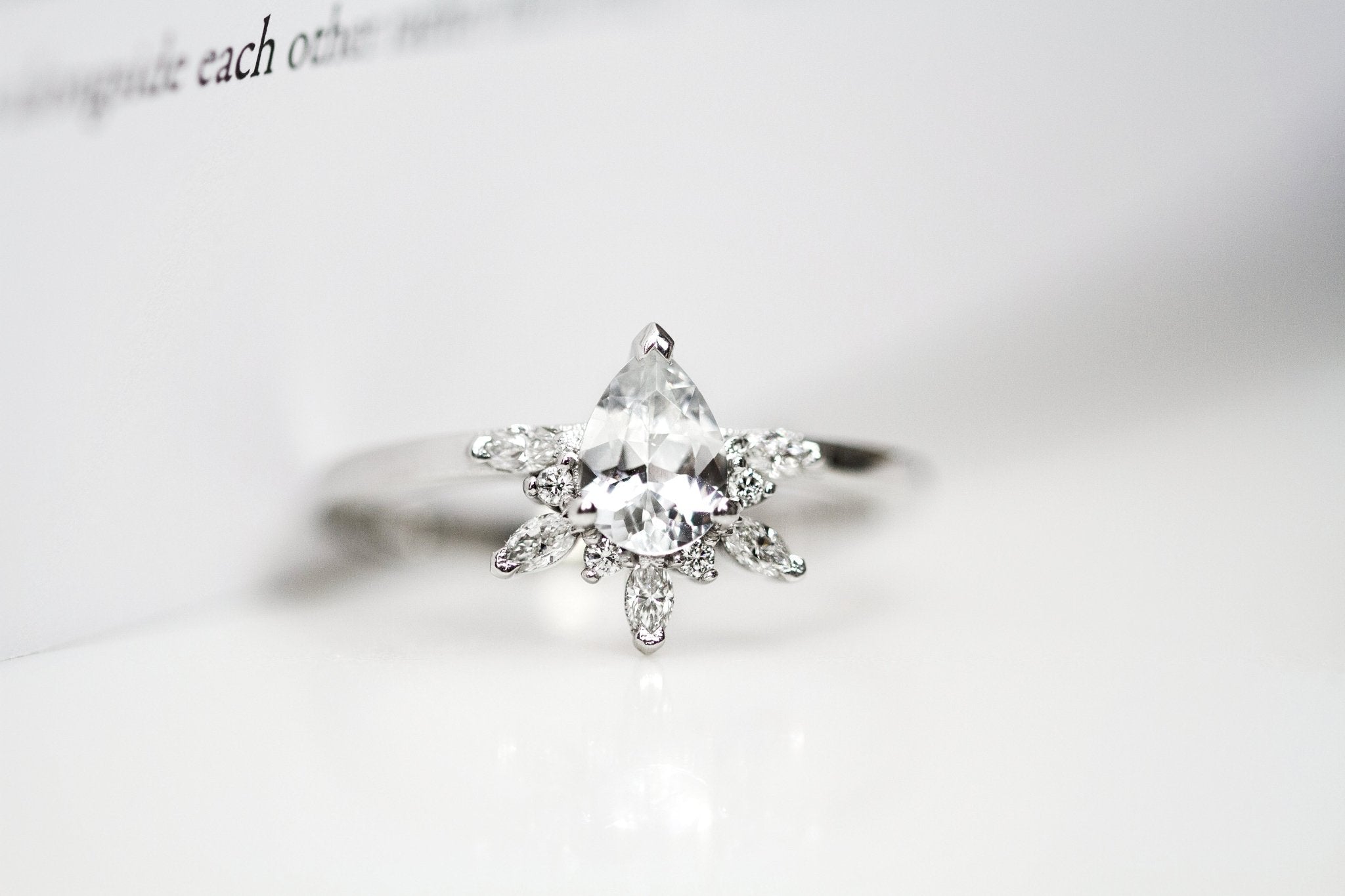 Rings-Feminine, nostalgic nod to the beauty, timelessness and grace of what it means to be woman. Centre stone is a stunning white sapphire completed with a divine diamond halo. Destined to be your forever obsession. Product Details - Features a 0.70ct natural white sapphire- Half halo features marquise and round F/SI1 natural diamonds (approximately 0.20ct)- Shop the Natasha Diamond Crown to complete the set- The ring is 1.85mm wide and 1.6mm thick-ELIISE MAAR JEWELLERY