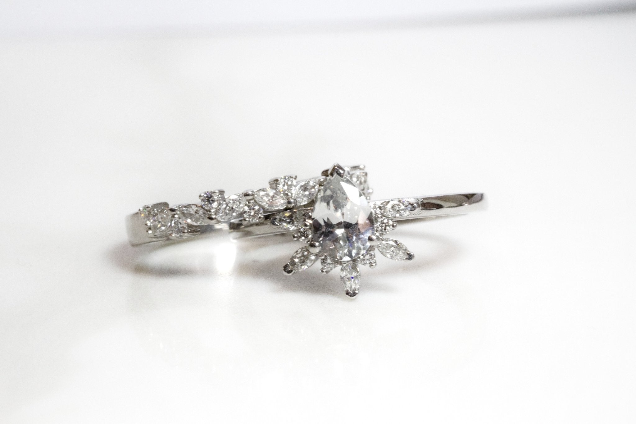 Rings-Feminine, nostalgic nod to the beauty, timelessness and grace of what it means to be woman. Centre stone is a stunning white sapphire completed with a divine diamond halo. Destined to be your forever obsession. Product Details - Features a 0.70ct natural white sapphire- Half halo features marquise and round F/SI1 natural diamonds (approximately 0.20ct)- Shop the Natasha Diamond Crown to complete the set- The ring is 1.85mm wide and 1.6mm thick-ELIISE MAAR JEWELLERY